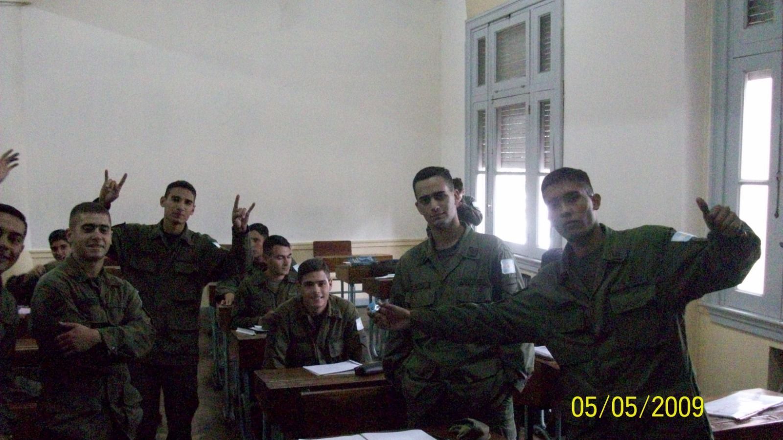 Grupo de personas uniformadas en un aula, algunas haciendo gestos con las manos. Fecha: 5 de mayo de 2009.