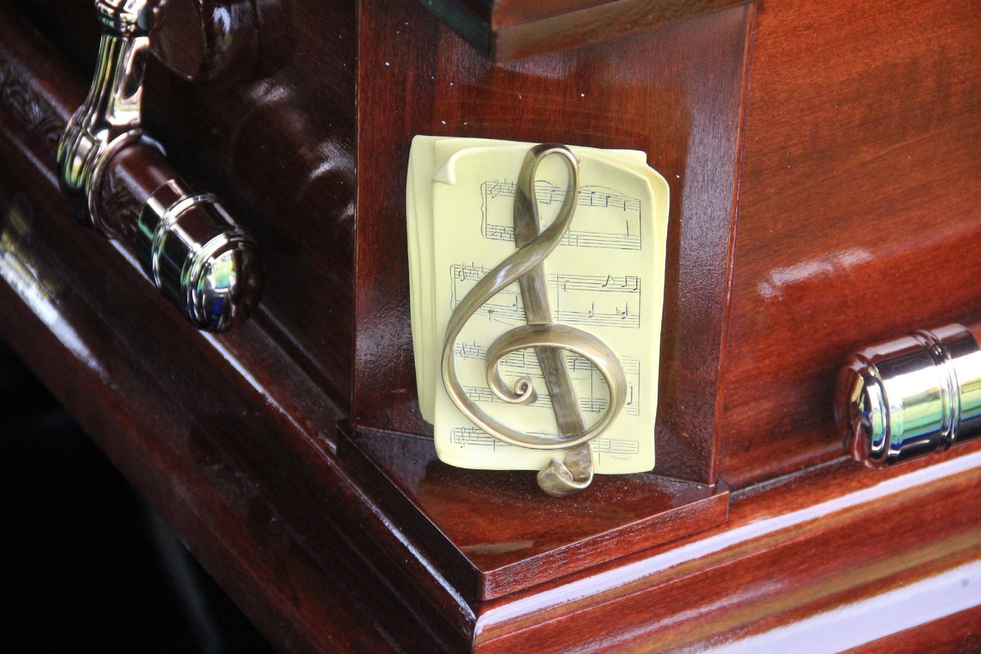 A wooden casket with a musical note emblem.