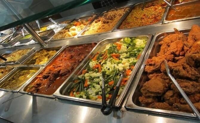 A buffet with various dishes: fried chicken, vegetables, and other entrees.