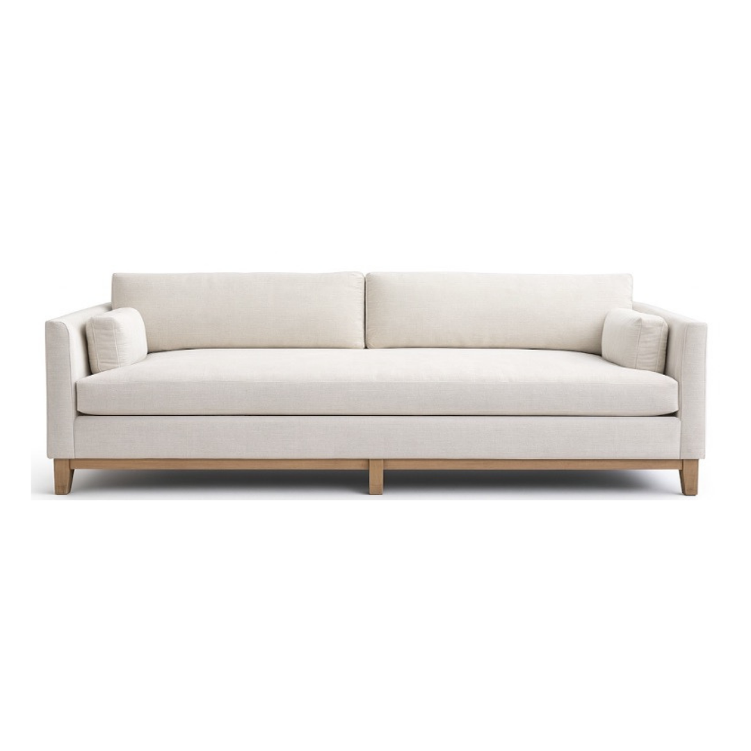 Cream-colored sofa with two back cushions, two arm cushions, and a wooden base, set against a white background.