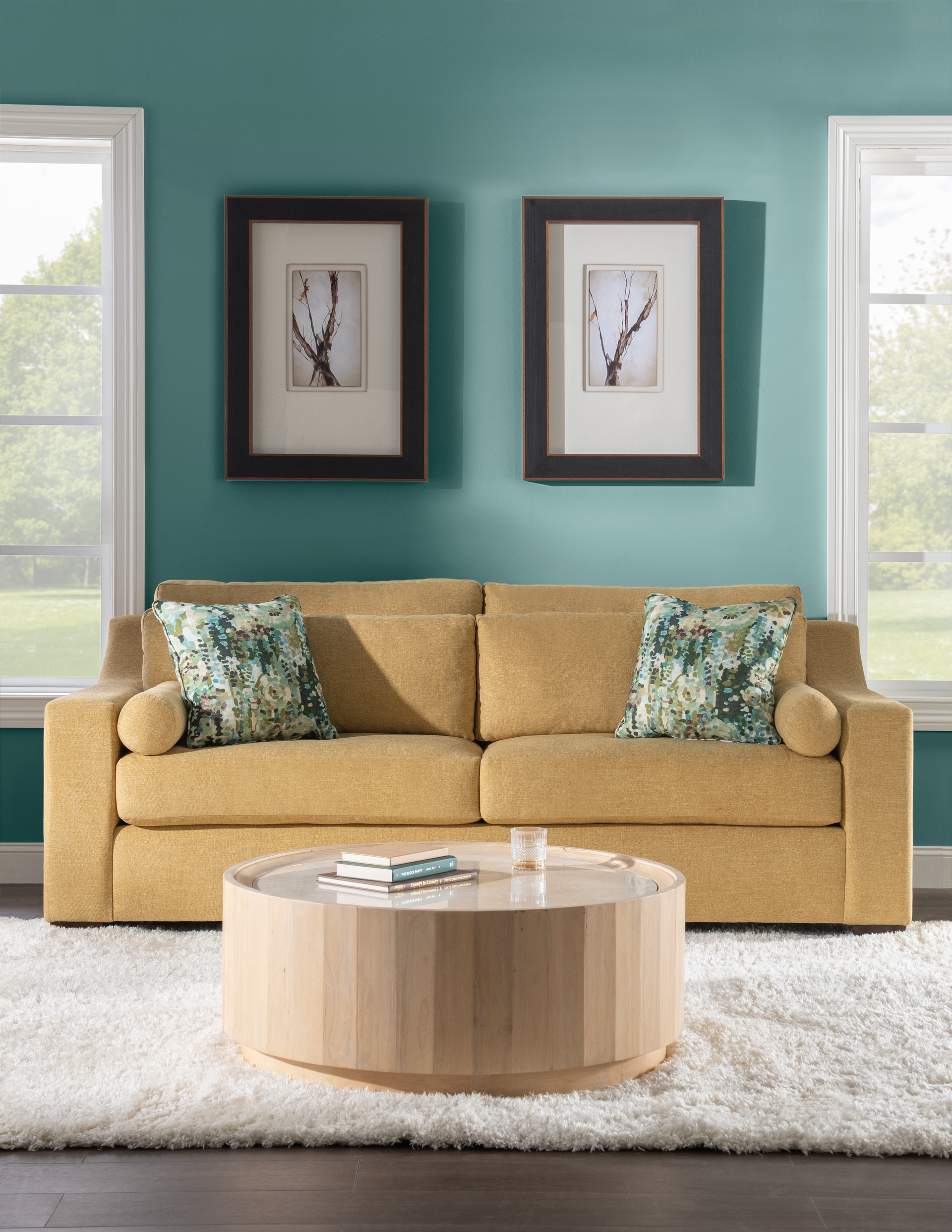 A living room with a large modern sectional couch and a rug.