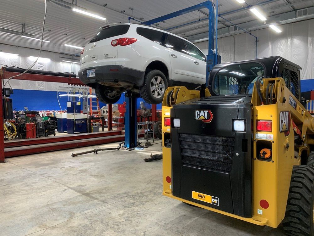 A car is sitting on top of a lift in a garage.