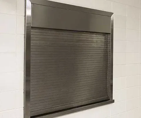 Stainless steel shuttered window in a tiled wall.