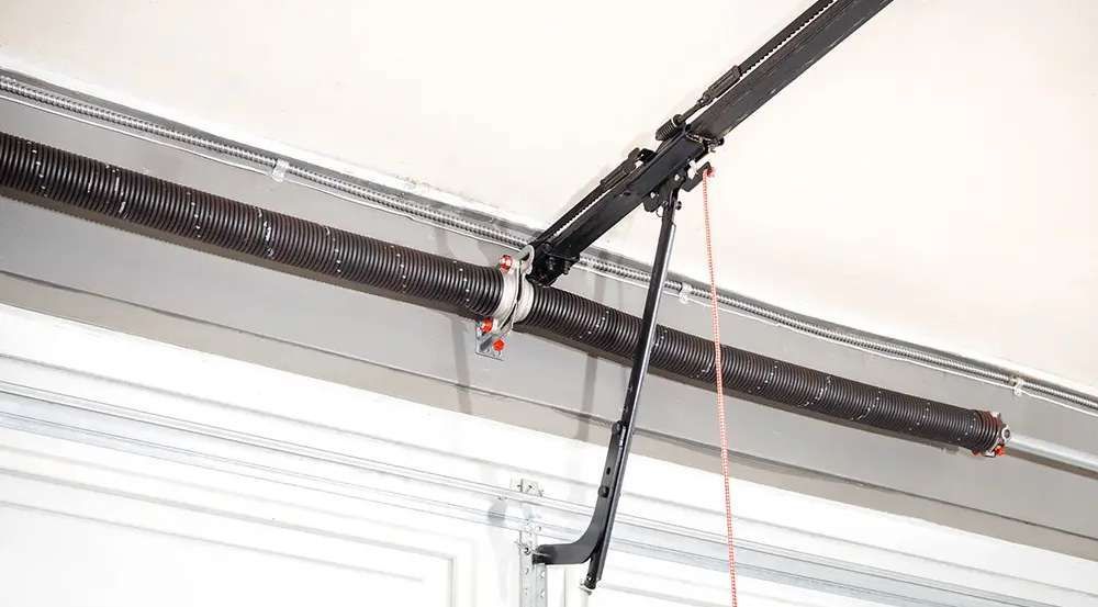 Garage door opener system with a spring and track.