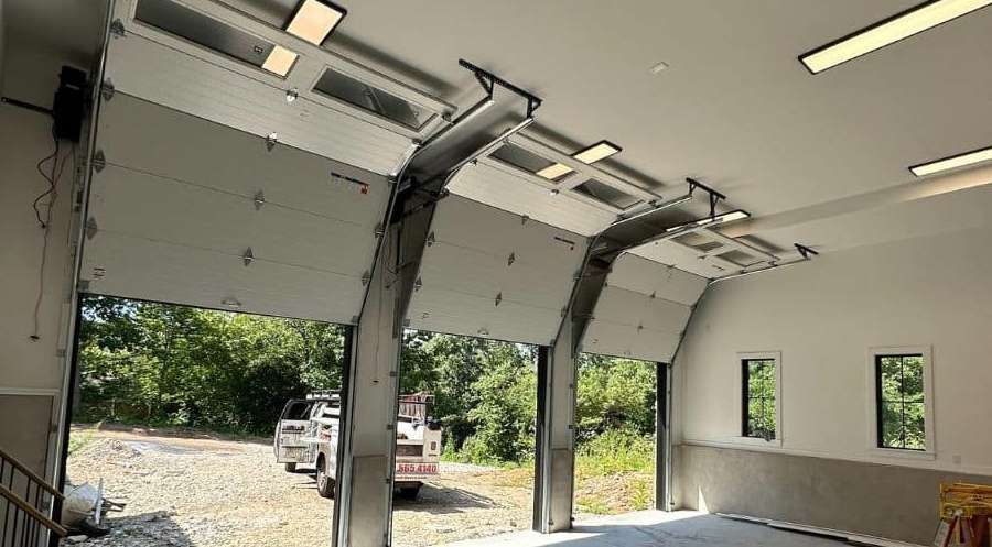 Open overhead doors of a building, with a truck parked in front.