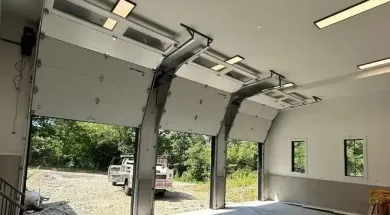 Open overhead doors of a building, with a truck parked in front.