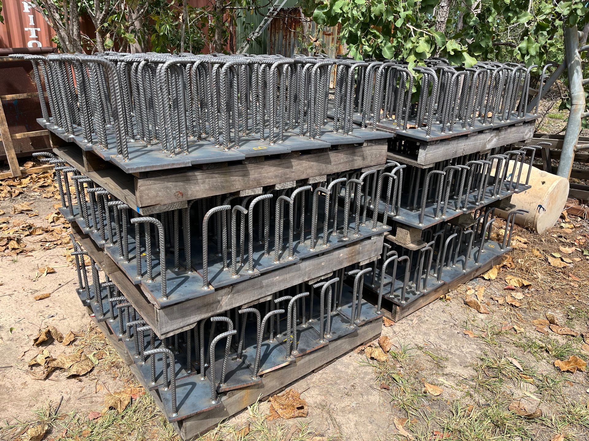 Stacked Black Plastic Crates Outdoors on Dirt, With Leaves and a Brick Wall — Greville Fabrication in Girraween, NSW