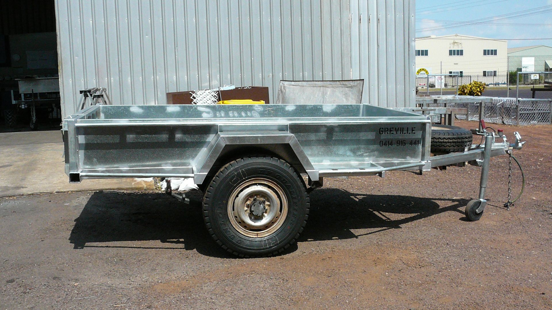 Metal Utility Trailer on a Paved Area, With ONE Wheel Visible and a Connecting Hitch — Greville Fabrication in Girraween, NSW