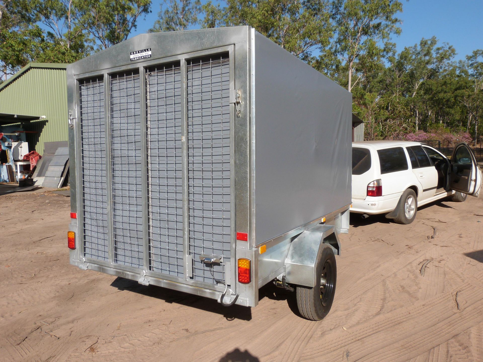 Gray Enclosed Trailer Hitched to a White Station Wagon on a Dirt Road — Greville Fabrication in Girraween, NSW