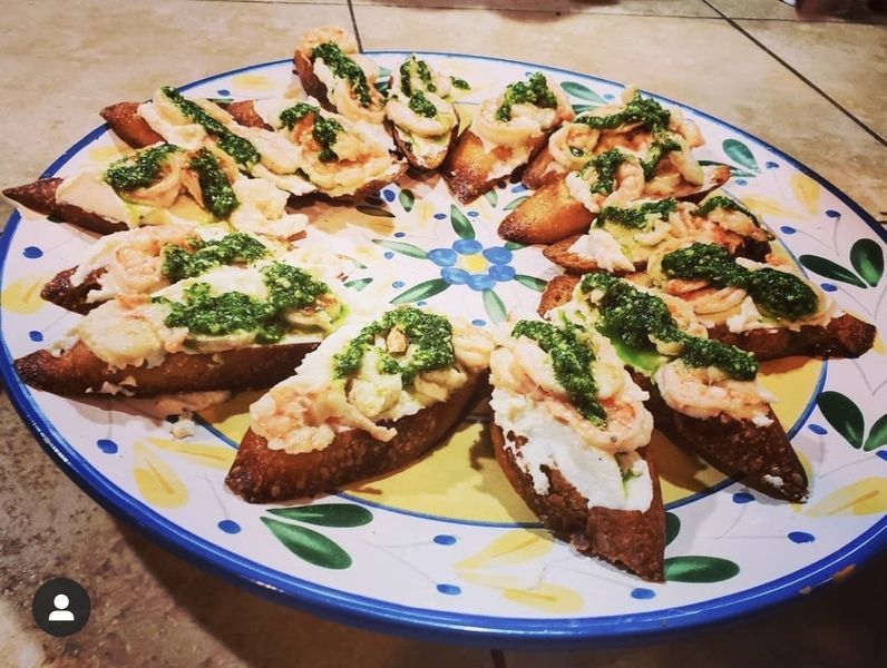 A plate of food with shrimp and pesto on it