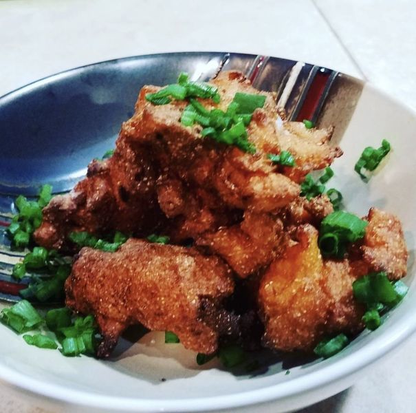 A bowl of fried food with green onions on top