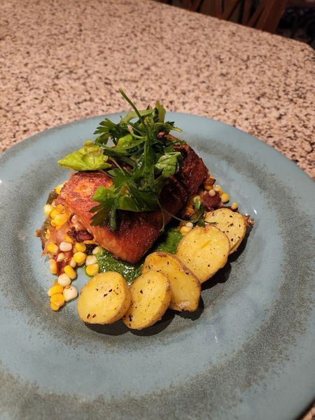 A plate of food with potatoes and corn on a table
