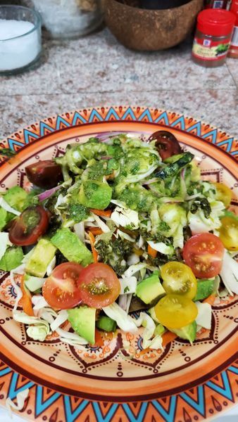 A plate of salad with tomatoes avocado and other vegetables