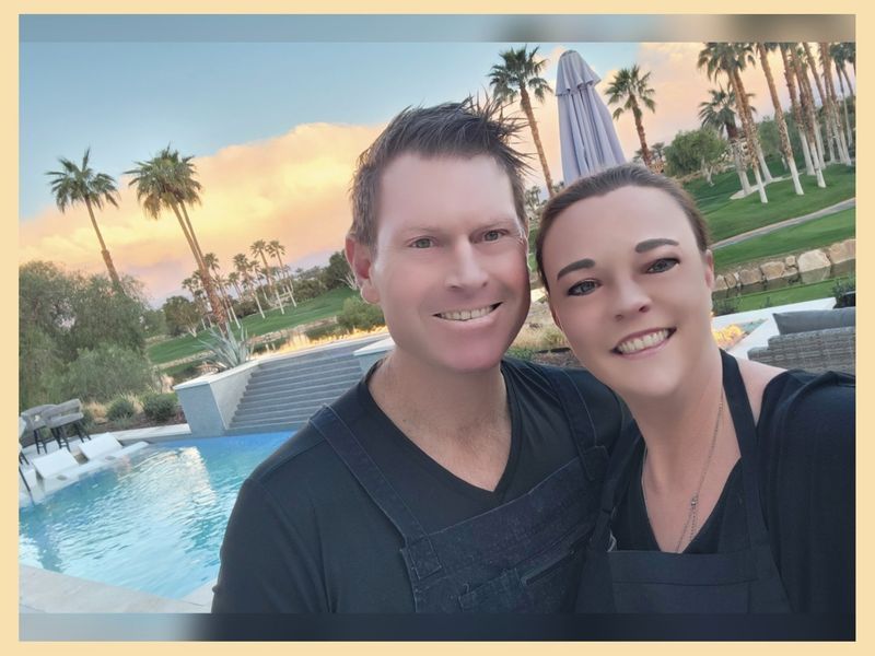 A man and a woman are posing for a picture in front of a pool.