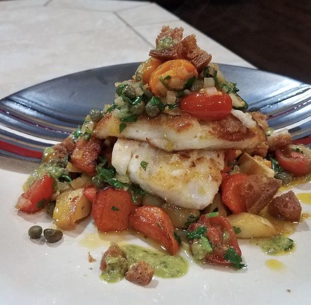 A plate of food with meat and vegetables on a table