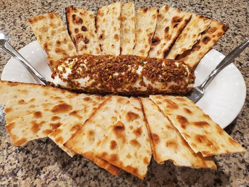 A white plate topped with bread and a roll of cheese.