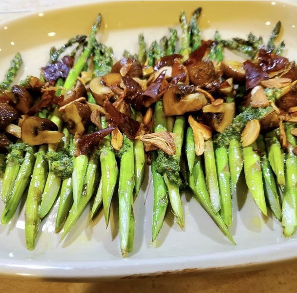 A white plate topped with asparagus and mushrooms