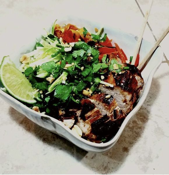 A bowl of food with meat and vegetables on a table
