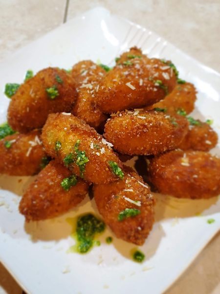 A white plate topped with fried chicken wings and parsley.