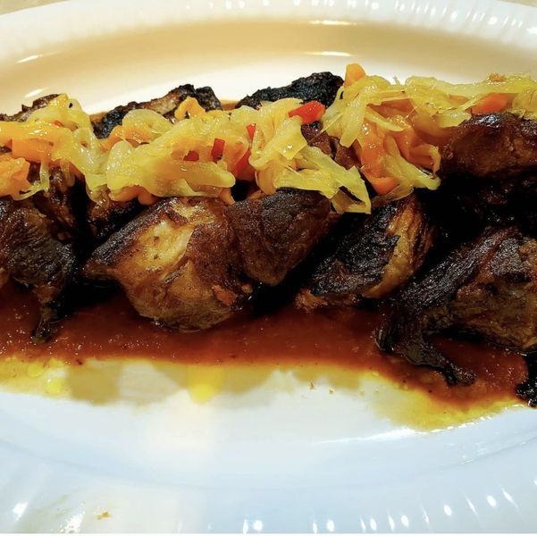 A white plate topped with meat and vegetables