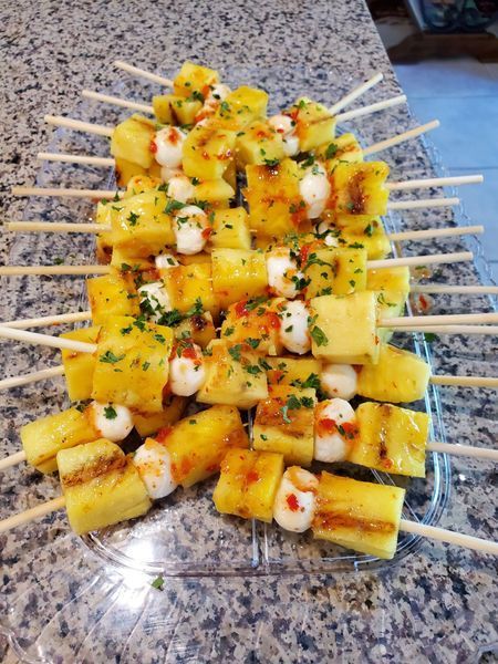 A tray of pineapple skewers on a table.