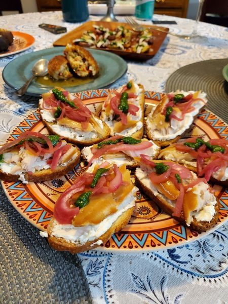 A plate of food is on a table with other plates of food