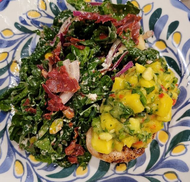 A plate of food with a salad and guacamole on it