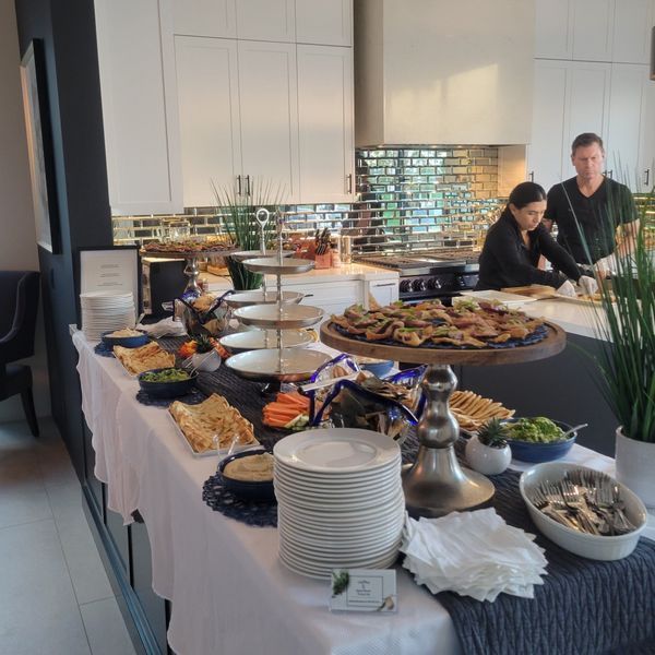 A buffet table with plates and bowls of food on it