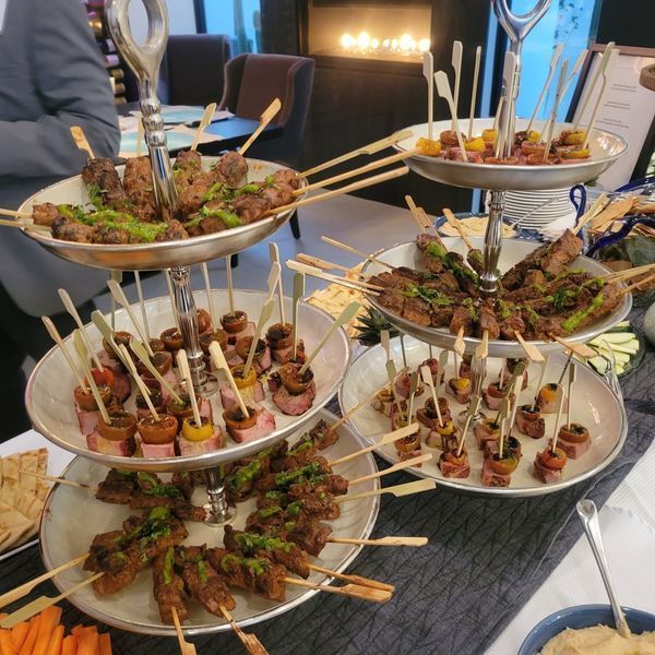 Several plates of food on sticks are on a table
