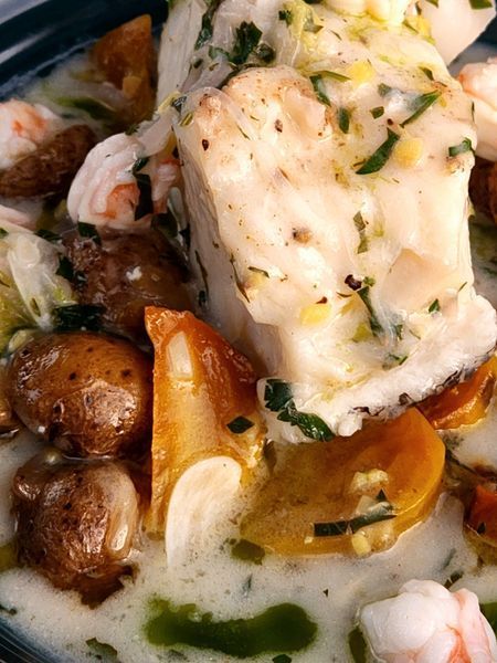 A close up of a plate of food with shrimp and potatoes
