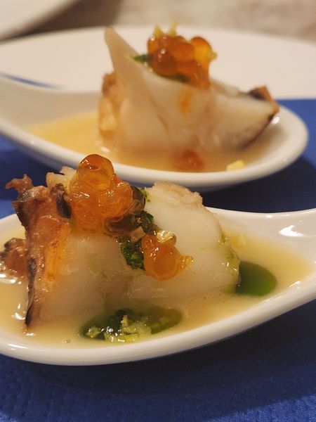 A close up of a spoon with a piece of food on it