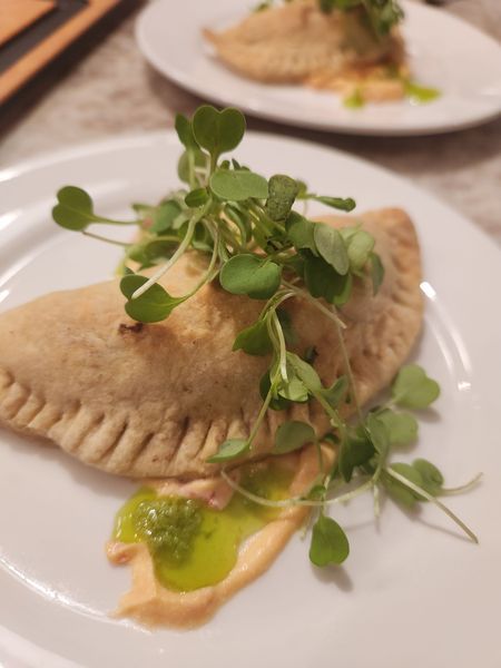 A close up of a plate of food with greens on top