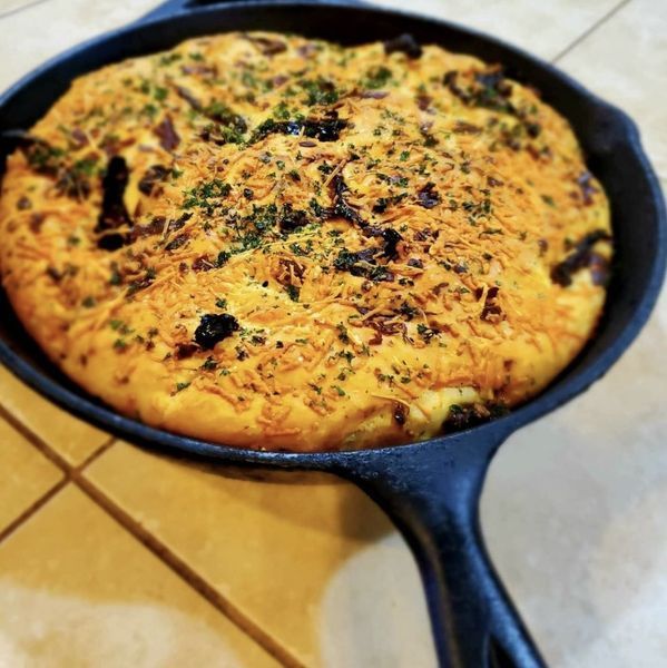 A skillet with a pizza in it on a table