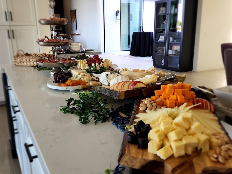 A buffet table with a variety of cheeses and fruits on it.