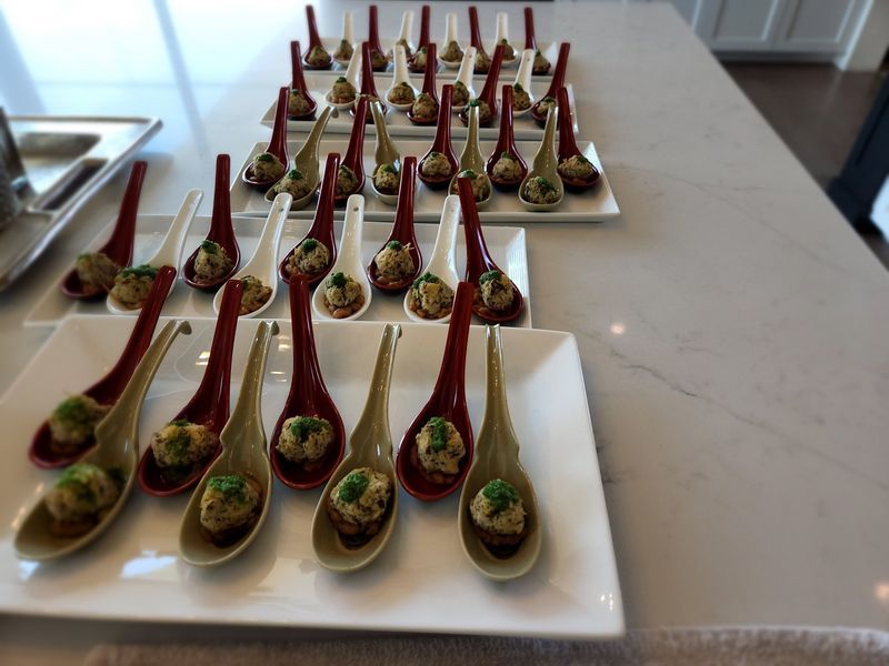 A white plate topped with spoons filled with food on a table.