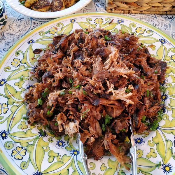 A plate of food with tongs on it on a table.