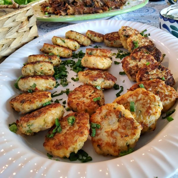 A white plate topped with fried food and green onions
