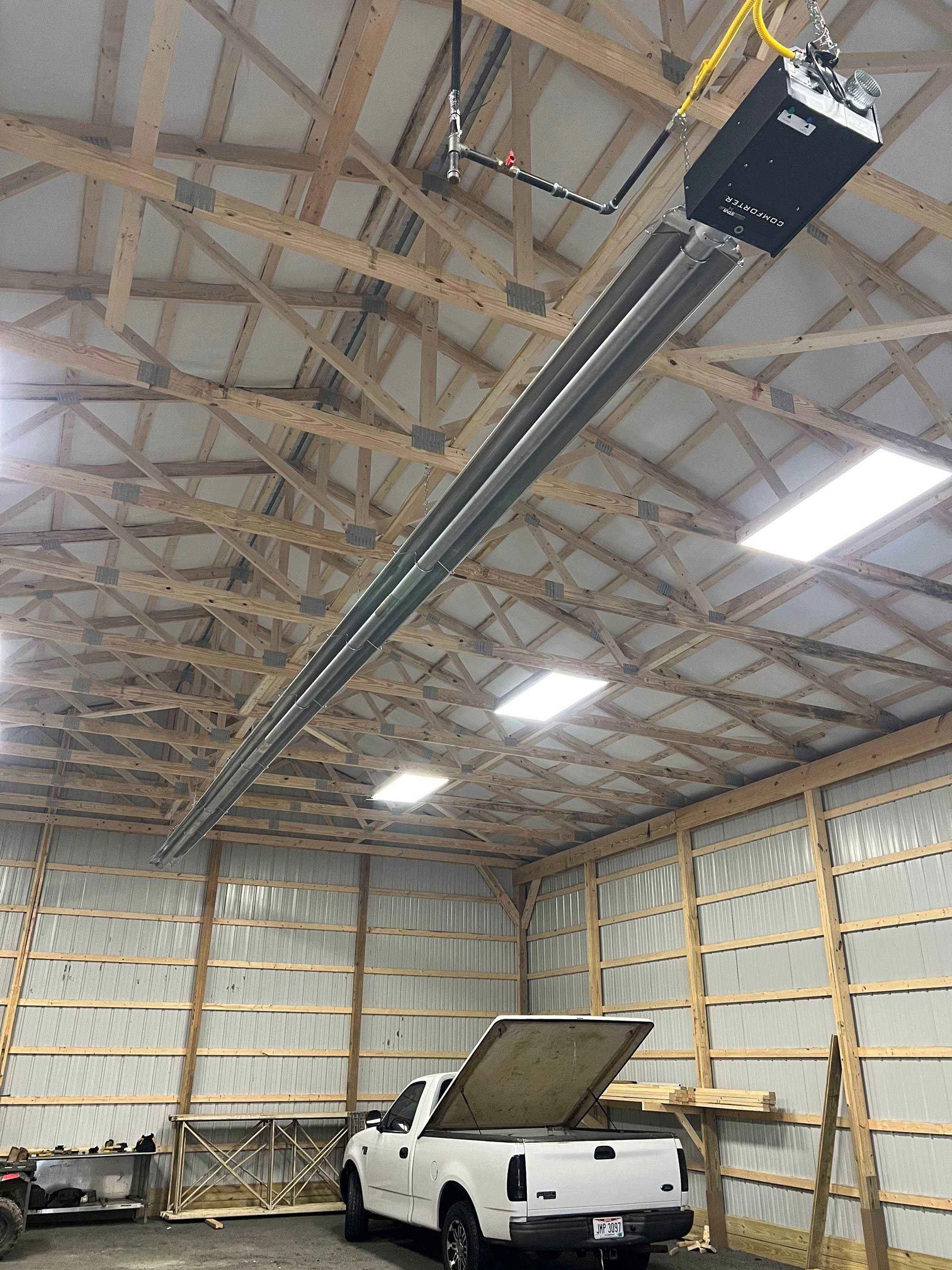 A white truck is parked in a garage with the lid open.