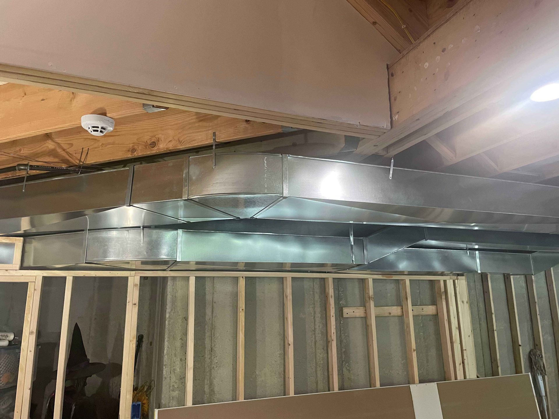 A room with a lot of metal pipes hanging from the ceiling.