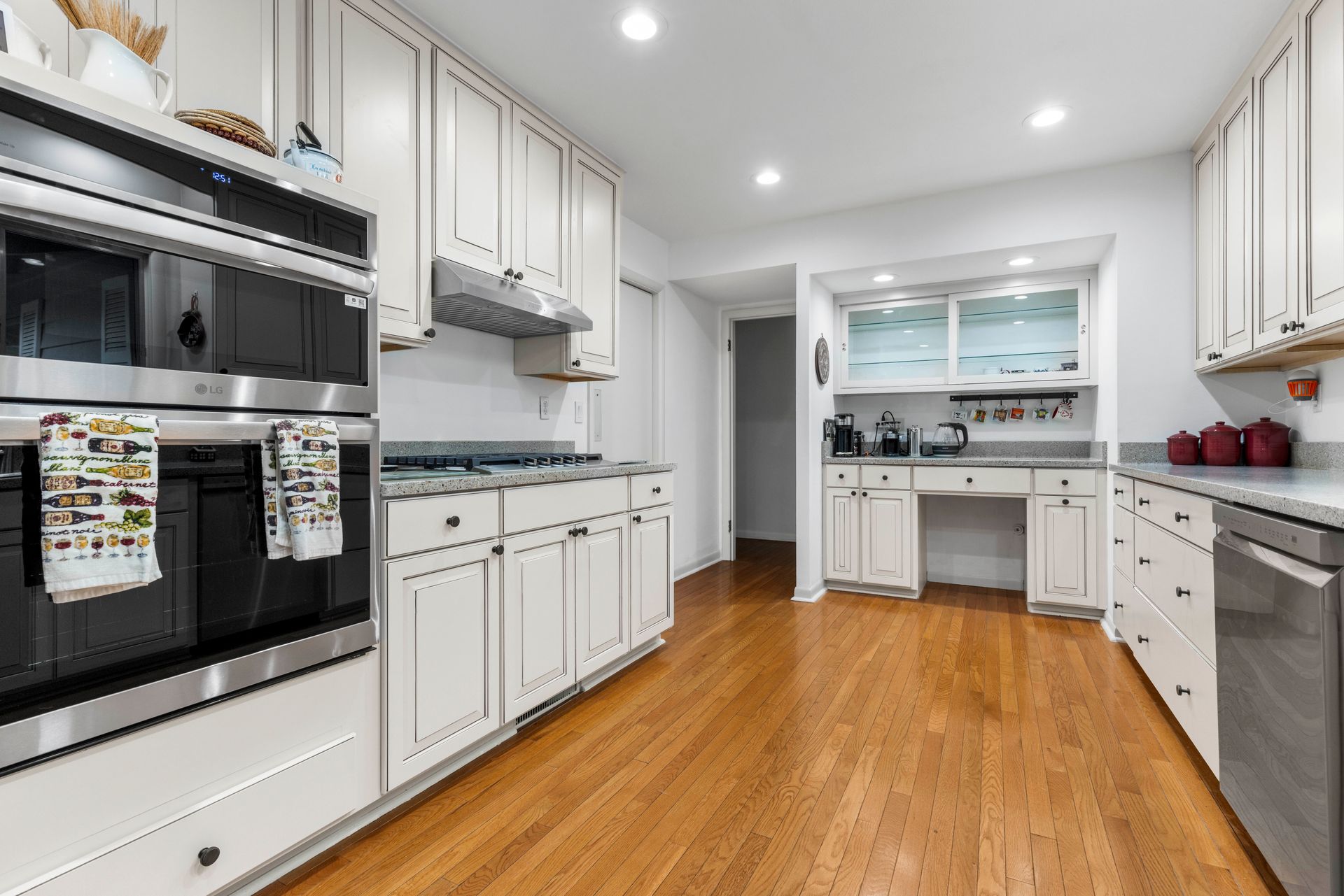 Kitchen with white cabinets, stainless steel appliances, and hardwood floors.