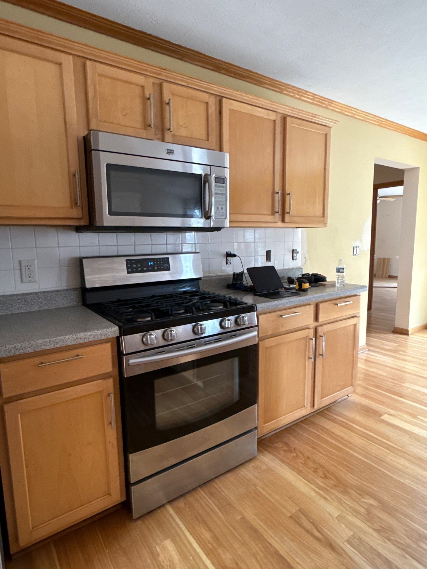 Kitchen with light wood cabinets, stainless steel appliances, and light-colored countertops.