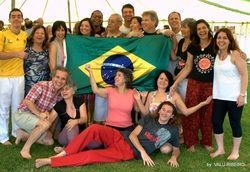 A group of people are posing for a picture with a brazilian flag.