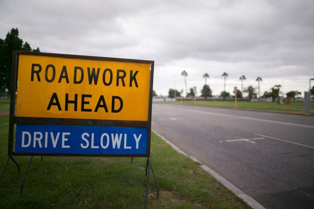 A Yellow Sign That Says Roadwork Ahead Drive Slowly — Payton Civil Products in Roma, QLD