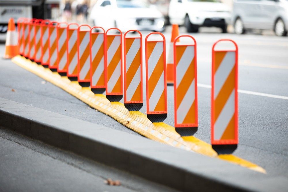 A Row of Orange and White Traffic Cones on the Side of a Road — Payton Civil Products in Gatton, QLD