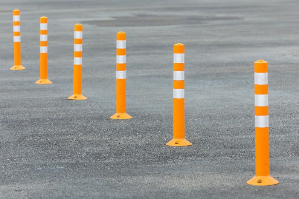 A Row of Orange and White Poles in a Parking Lot — Payton Civil Products in Wilsonton, QLD