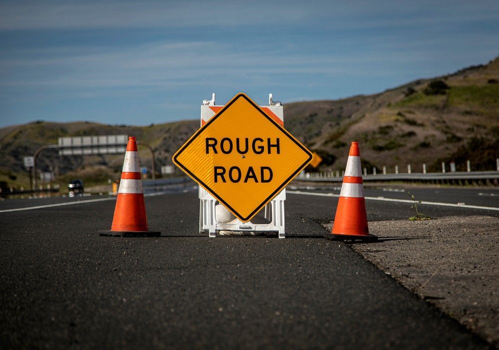 A Rough Road Sign is Sitting on the Side of a Highway — Payton Civil Products in Wilsonton, QLD