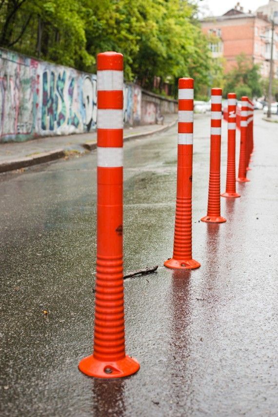 A Row of Orange and White Traffic Poles on a Wet Street — Payton Civil Products in Kingaroy, QLD