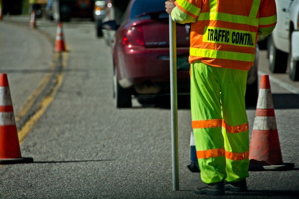 A Traffic Control Officer is Standing on the Side of the Road — Payton Civil Products in Wilsonton, QLD