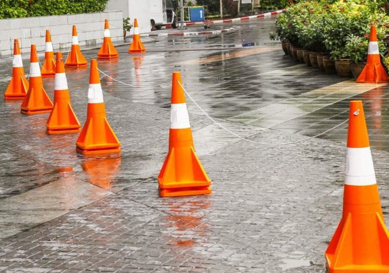A Row of Orange and White Traffic Cones on a Wet Street — Payton Civil Products in Warwick, QLD