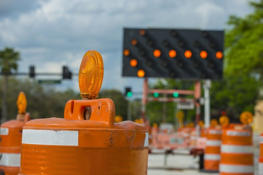 A Bunch of Orange Traffic Cones Are Sitting on the Side of a Road — Payton Civil Products in Gatton, QLD